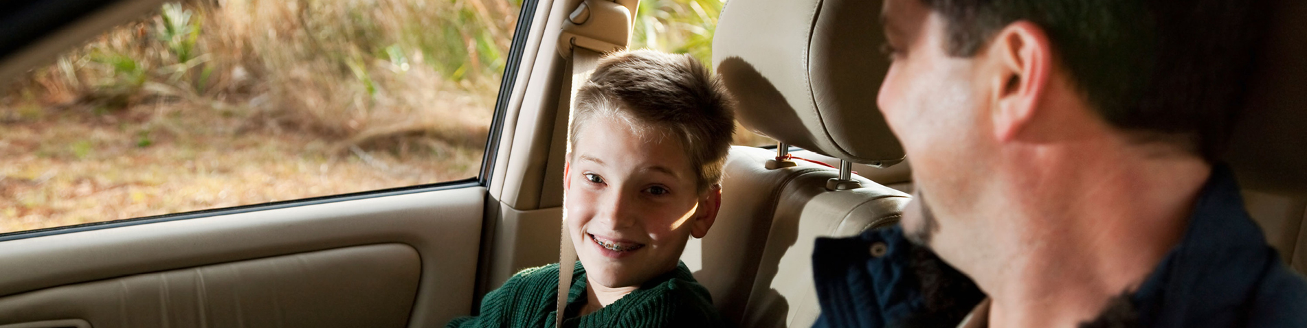 kind kijkt ouder aan in de auto