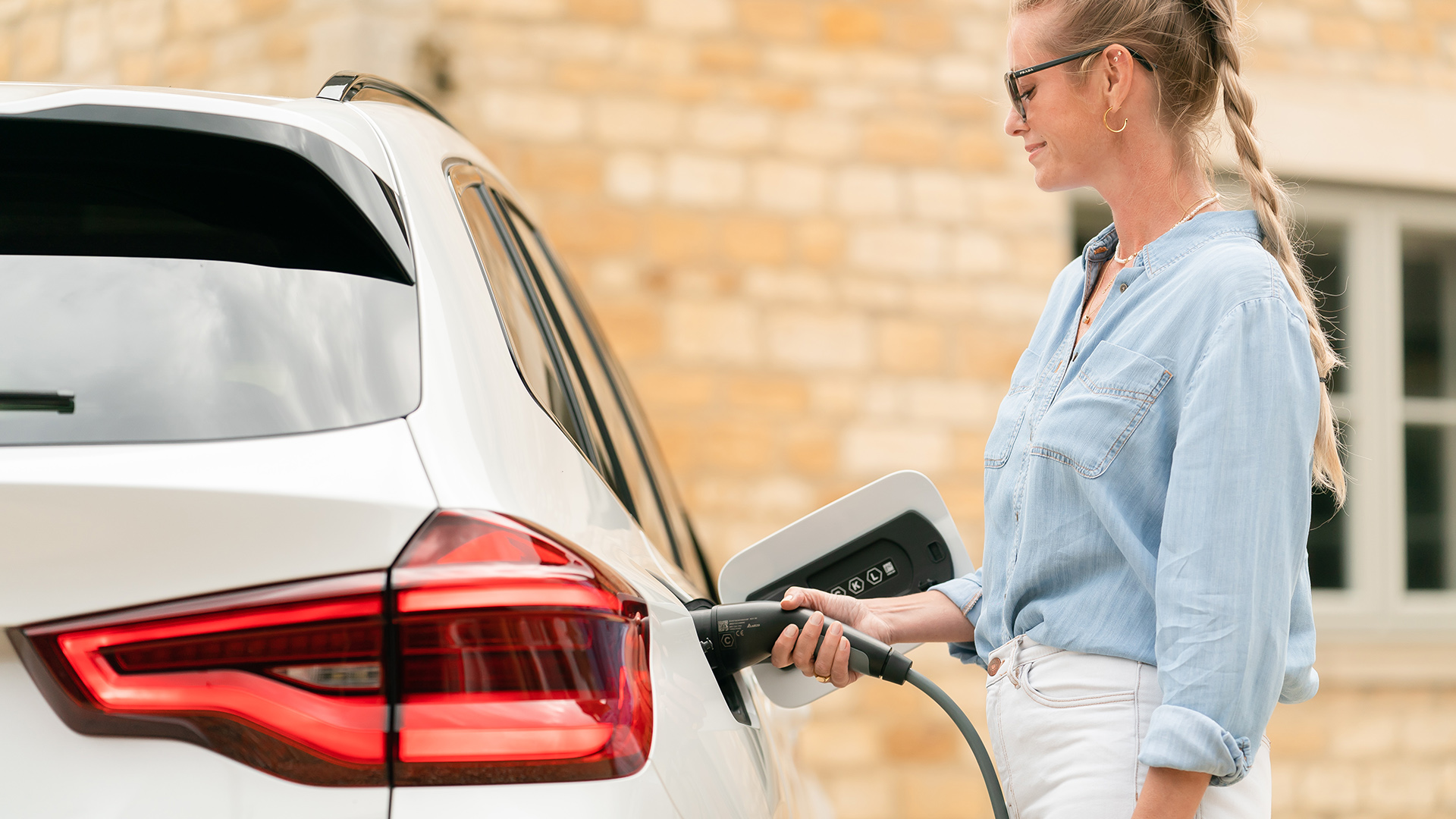 Vrouw laadt elektrische wagen op